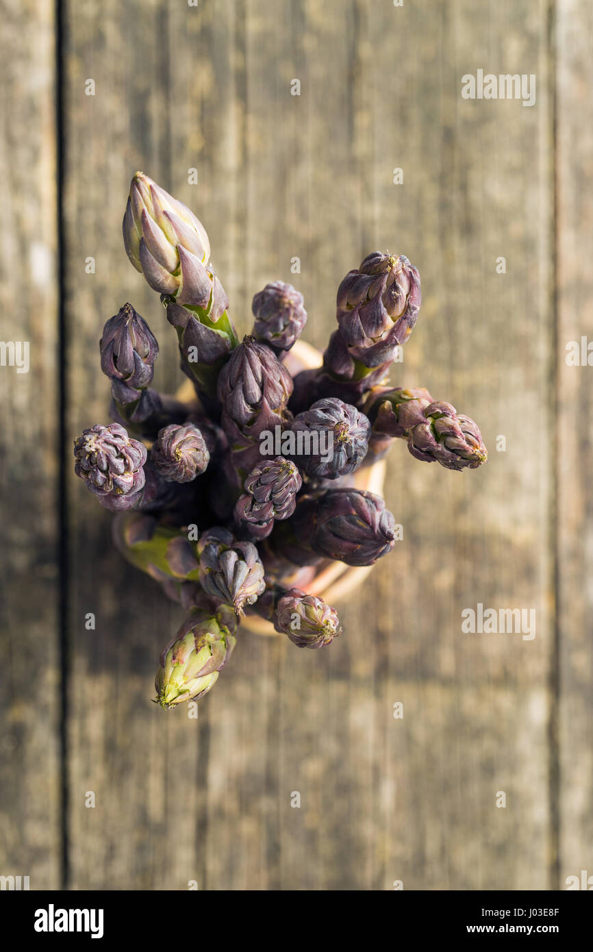 Frischen violetten Spargel auf alten Holztisch. Stockfoto