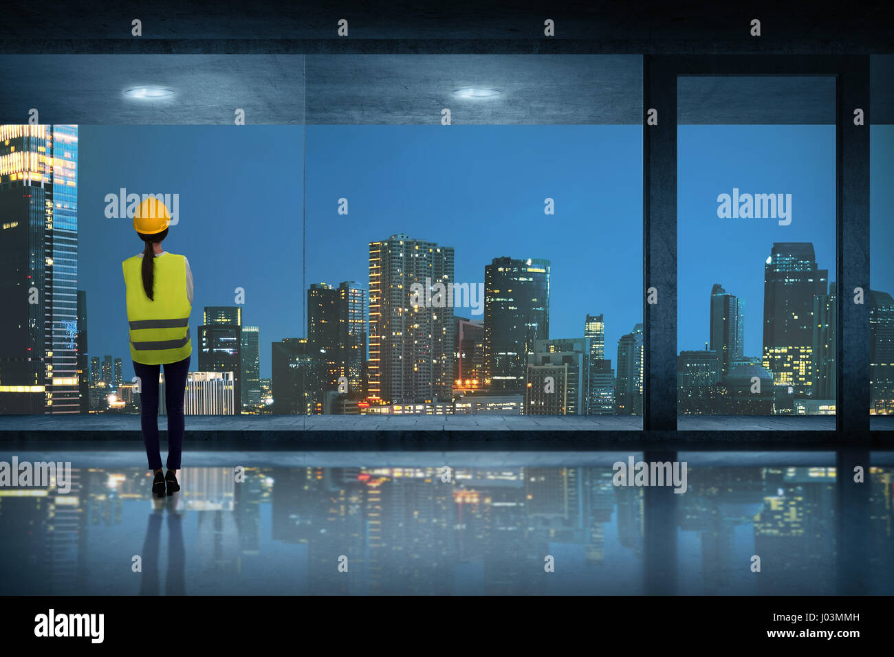Junge asiatische Ingenieur Frau stehend sehen durch Fensterglas in der Nacht Stockfoto