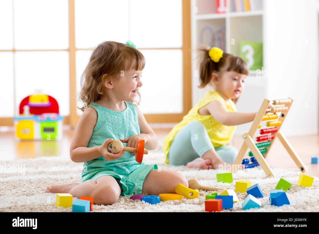 Kleine Kinder spielen mit Abakus und Konstruktor Spielzeug im Kindergarten, Kindergarten oder Kindertagesstätte center Stockfoto