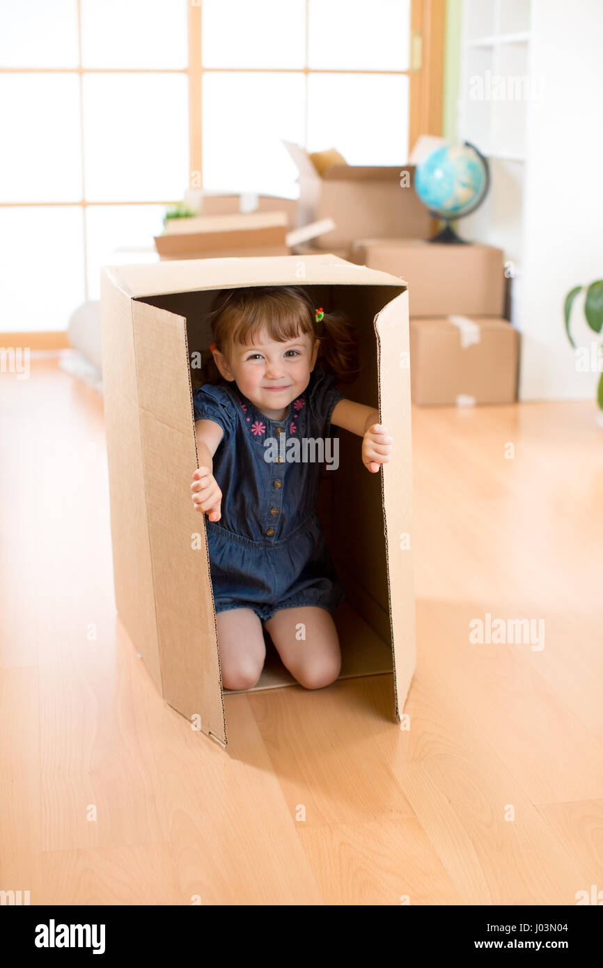 Glückliches Kind spielen mit Kisten nach dem Umzug in neues Haus Stockfoto