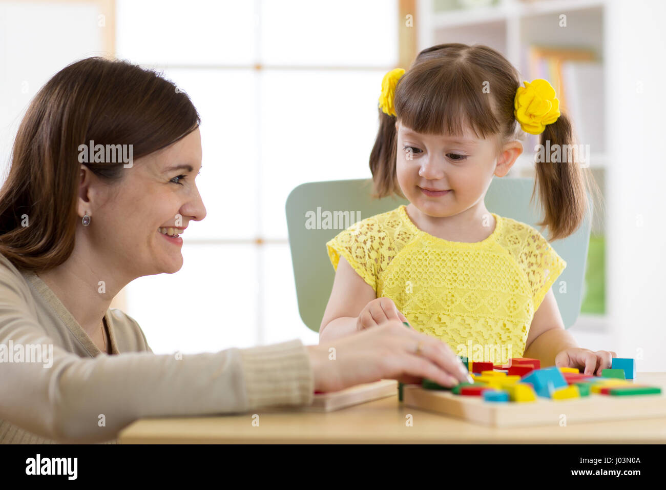 Frau und Kind Mädchen spielen logische Spielzeug zu Hause Stockfoto