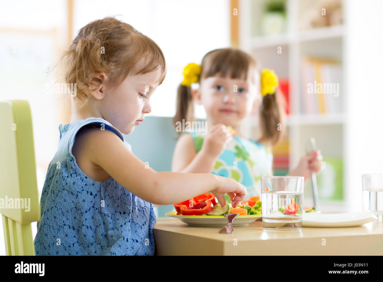 Kinder Kinder essen Gemüse im Kindergarten oder zu Hause Stockfoto