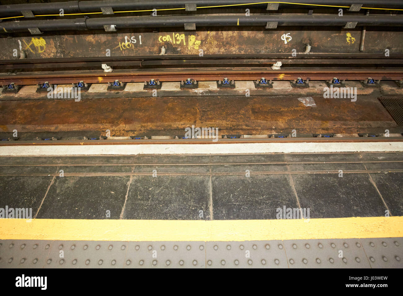 gelbe Linie und Nieten Texturen Kacheln markieren Rand der Plattform in der James Street u-Bahn Bahnhof Liverpool UK Stockfoto