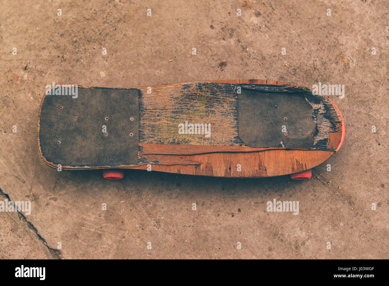 Alten verwitterten Skateboard auf Betonoberfläche, aufgegeben in der Skate-Park, Draufsicht, selektiven Fokus Stockfoto