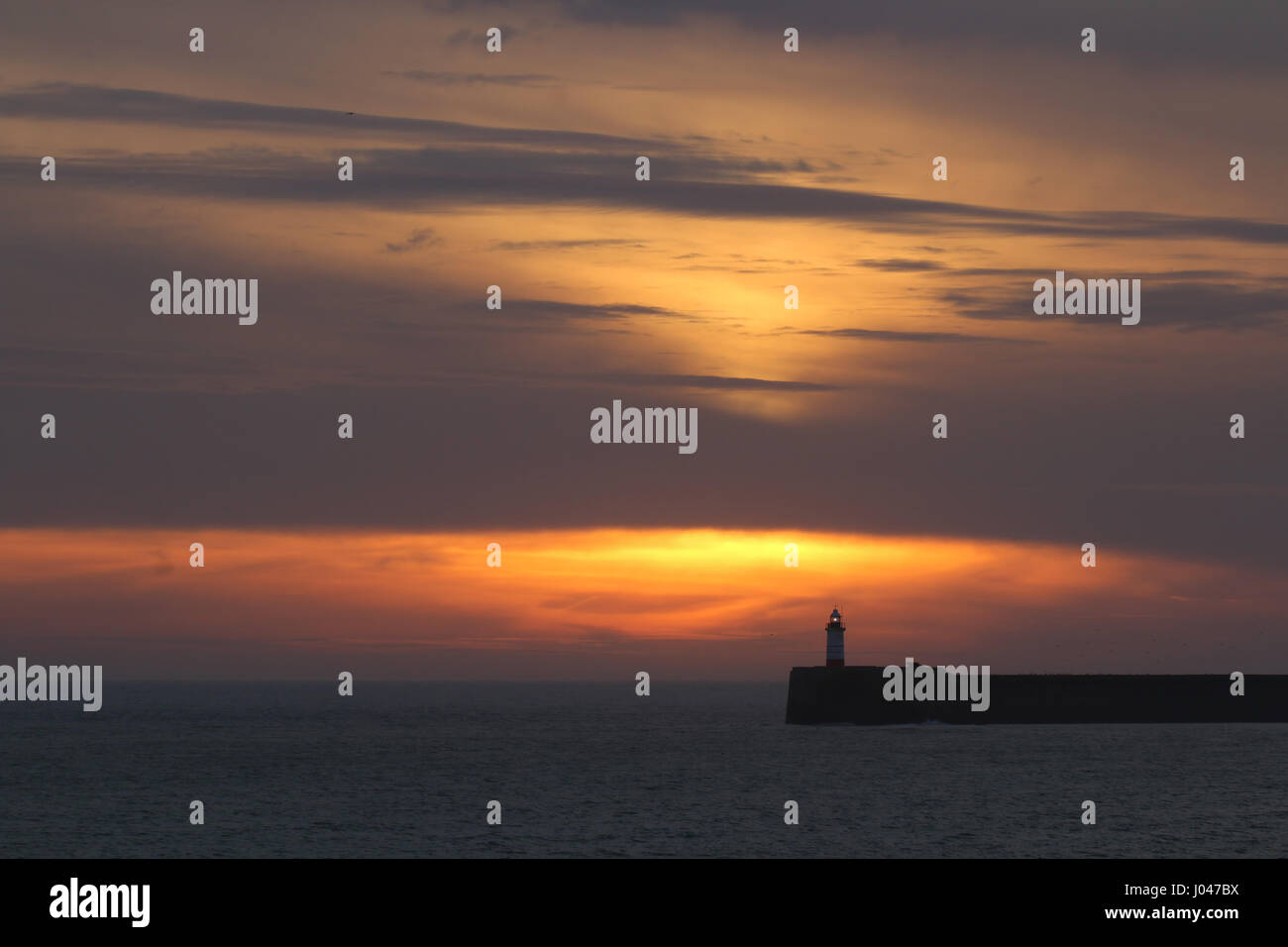 Sonnenuntergang Himmel und Wolken über Leuchtturm Newhaven, East Sussex. Stockfoto