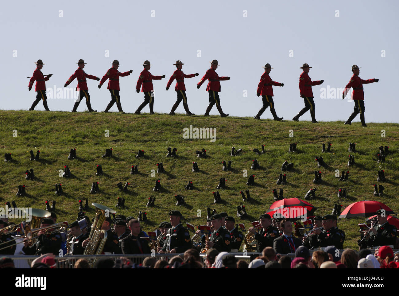 Angehöriger der Royal Canadian Mounted Police marschieren vorbei Stiefel von kanadischen und französischen Jugendlichen auf dem Gelände platziert, Kanadier getötet in der Schlacht - während eine Gedenkfeier im Vimy Memorial Park in Frankreich, während der Feierlichkeiten zum 100. Jahrestag der Schlacht von Vimy Ridge zu vertreten. Stockfoto