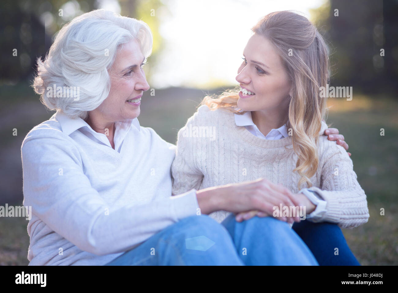 Liebende Frau unterhalten mit alten Mutter im park Stockfoto