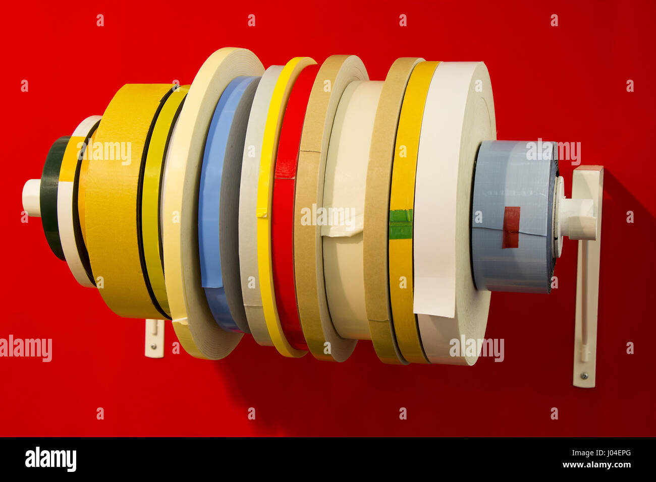 Vielzahl doppelte Klebeband in; Rollen der verschiedenen Arten von Band mit rotem Hintergrund Stockfoto