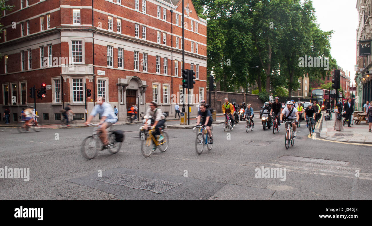 London, England - 5. Juli 2011: Pendler Radfahrer auf den Weg von ein grünes Licht an einer belebten Straßenkreuzung im Zentrum von London. Stockfoto