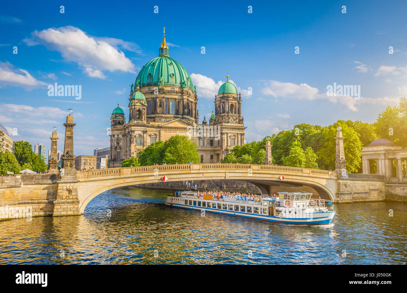 Schöne Aussicht auf historische Berliner Dom (Berliner Dom) an der berühmten Museumsinsel mit Schiff, vorbei an der Friedrichsbrucke Brücke an Spree bei Sonnenuntergang Stockfoto