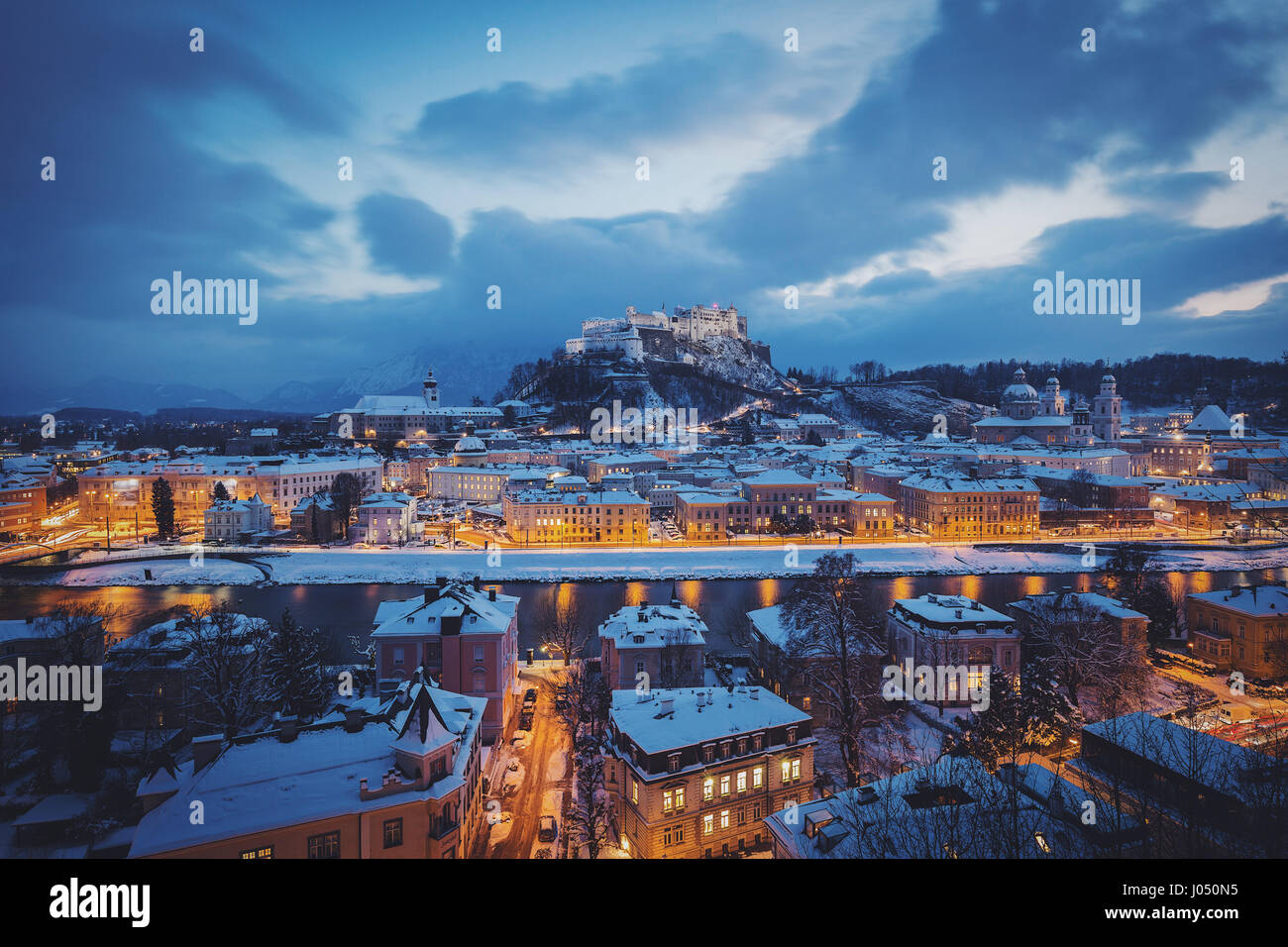 Klassische Ansicht von der historischen Stadt Salzburg mit der berühmten Festung Hohensalzburg und Salzach Fluss beleuchtet in schöne Dämmerung im Winter, Österreich Stockfoto