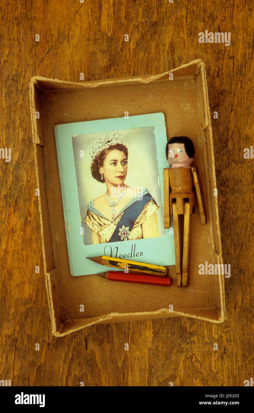 Karton mit Vintage Ordner für Nähnadeln mit Foto der jungen Königin Elizabeth II auf seiner Vorderseite und Peg-Puppe und Bleistifte Stockfoto