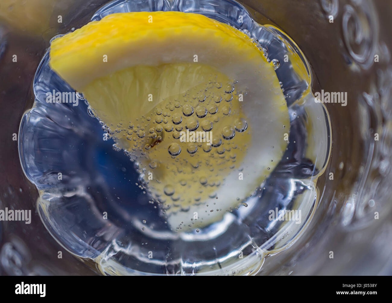 eine Zitronenscheibe in funkelndes Wasser getaucht. Nahaufnahme Stockfoto