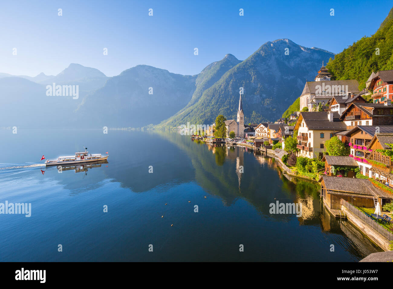Klassische Postkartenblick auf berühmte Hallstätter See Stadt in den Alpen mit Passagier Schiff im malerischen goldenen Morgenlicht an einem sonnigen Tag im Sommer Stockfoto