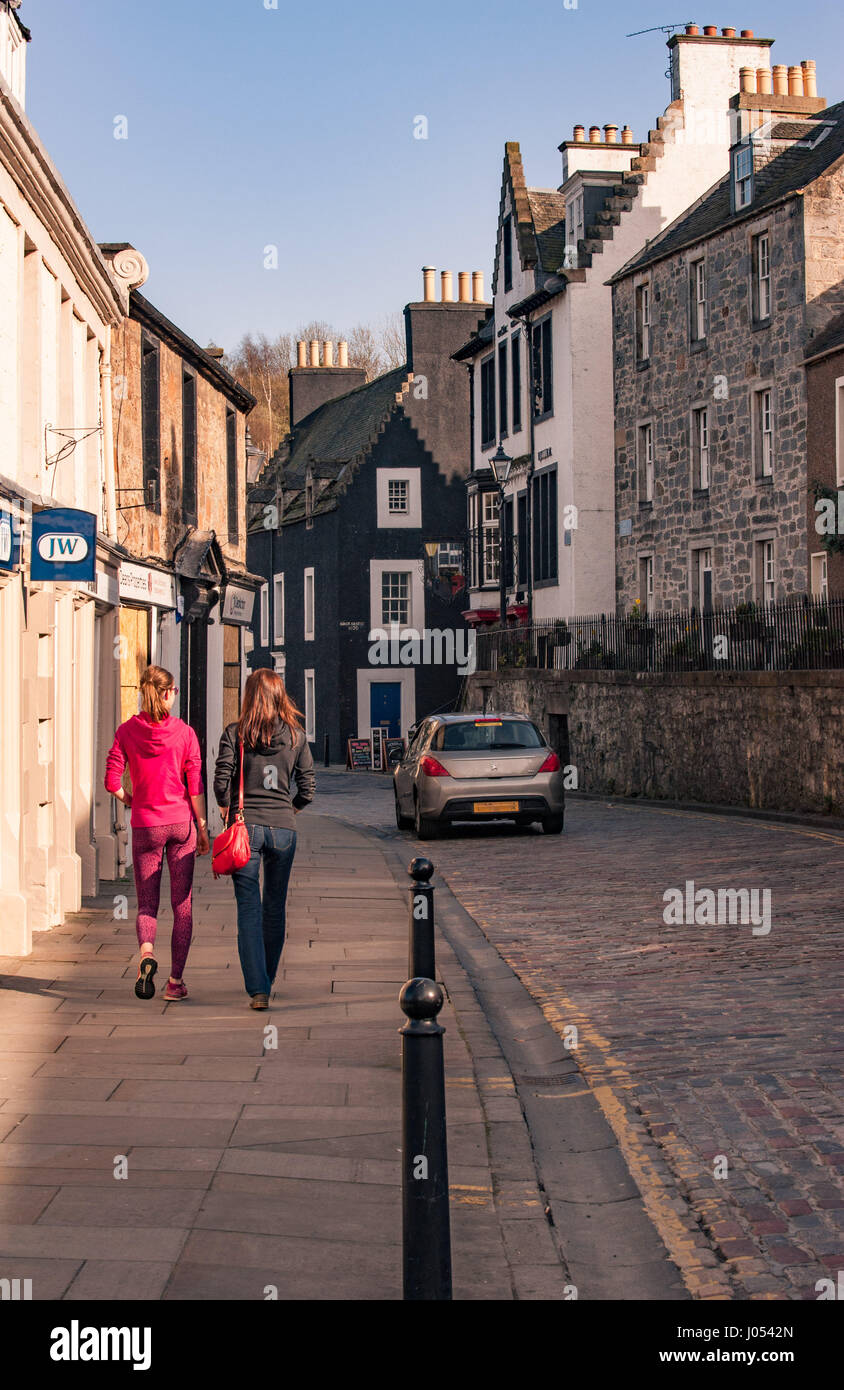 Zwei sportliche Frauen spazieren entlang der Hauptstraße in Queensferry, Schottland Stockfoto