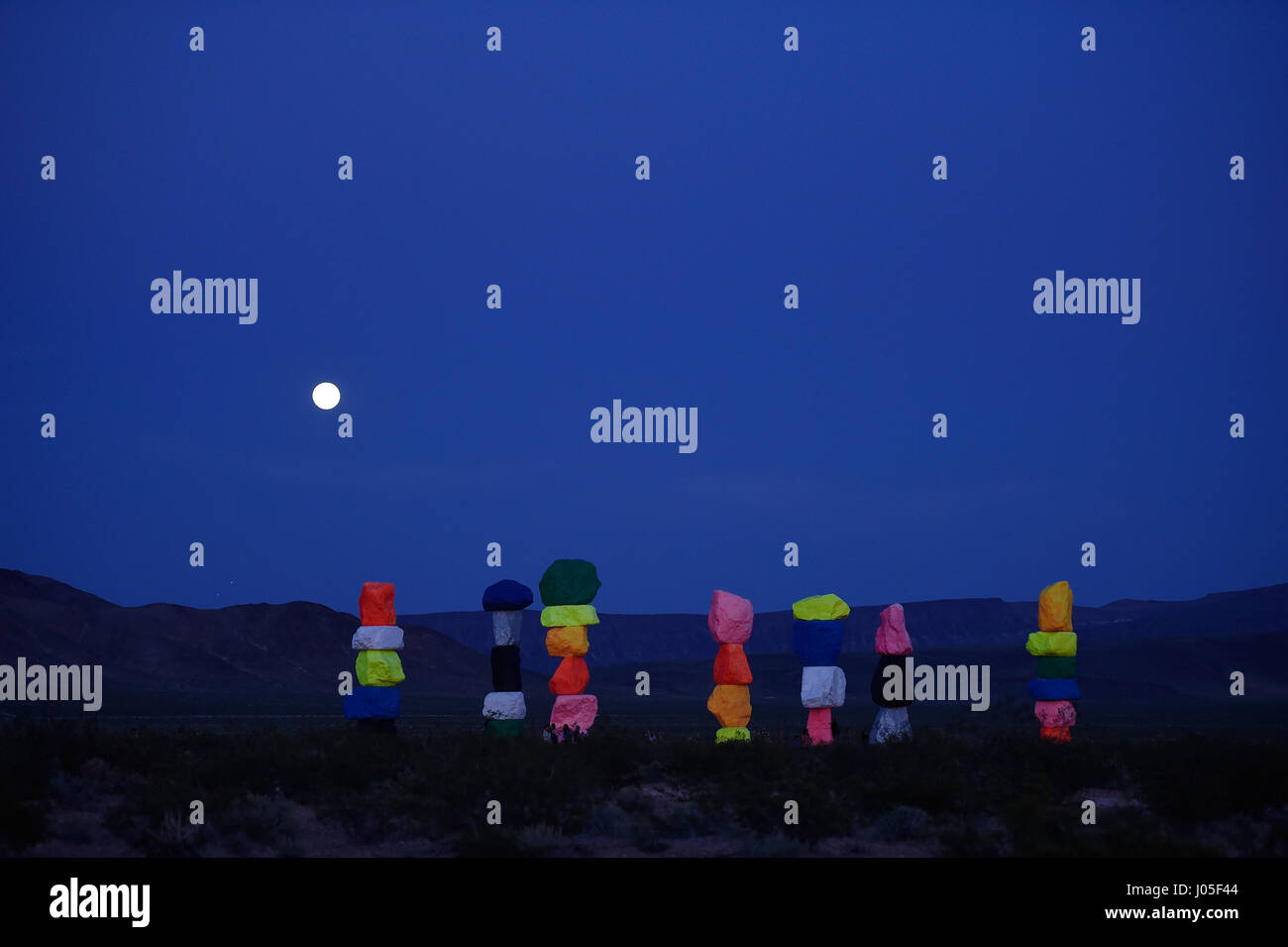 Jean, Nevada, USA. 10. April 2017. Ein Vollmond steigt über die große Kunst im öffentlichen Raum-Installation mit dem Titel sieben Magic Mountains des Schweizer Künstlers Ugo Rondinone 10. April 2017 in der Nähe von Jean, Nevada. Das Kunstwerk, bestehend aus sieben Türme der bunten, gestapelte Felsen stehend mehr als dreißig Fuß hoch, wird voraussichtlich bis Mai 2018 angezeigt werden. Bildnachweis: David Becker/ZUMA Draht/Alamy Live-Nachrichten Stockfoto