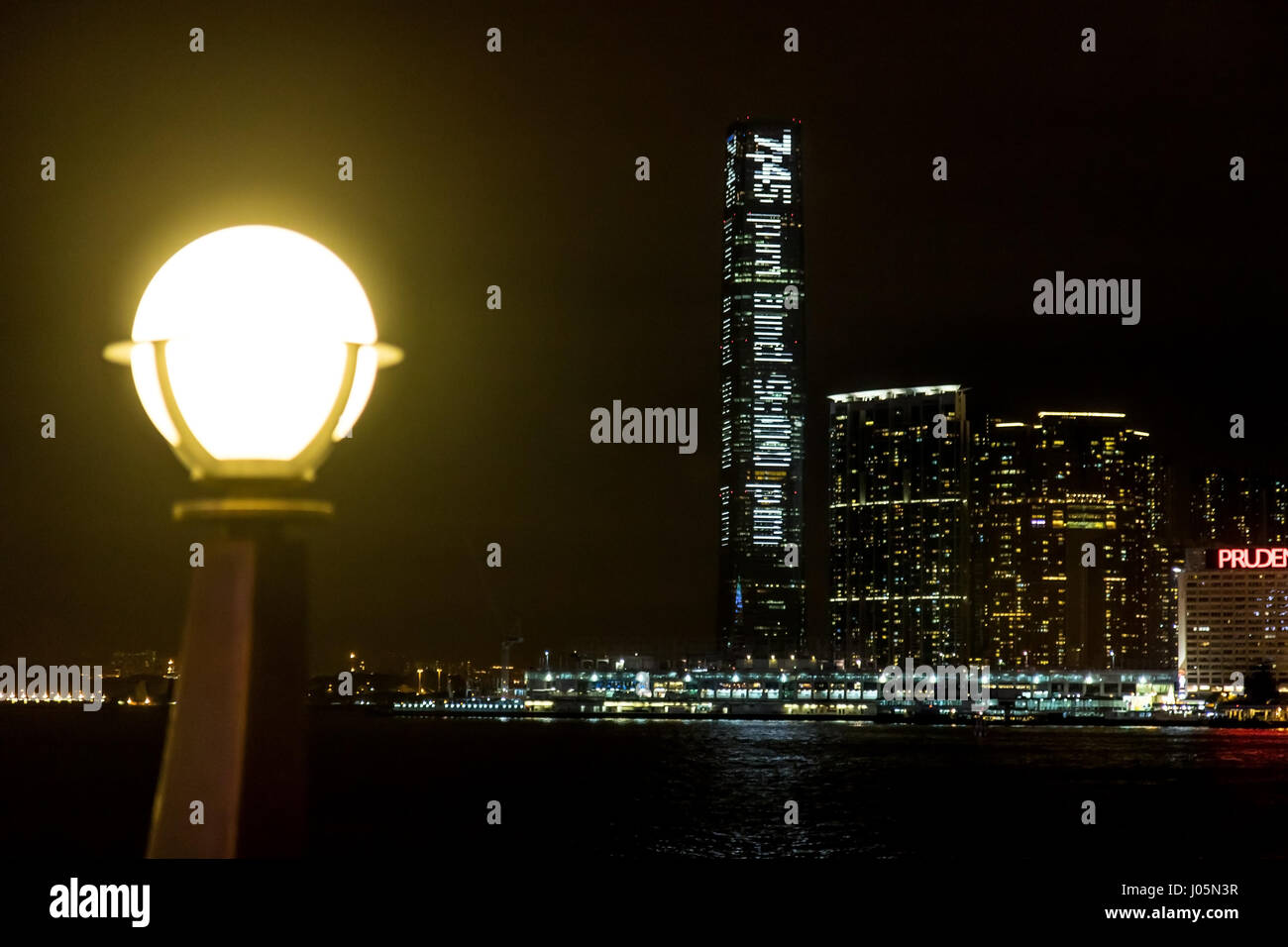 Beleuchtung Lampe am Ufer mit Blick auf die beleuchteten Wolkenkratzer in der Nacht, Hong Kong. Stockfoto