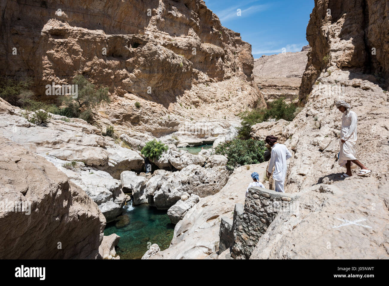 Menschen Wandern und Schwimmen im klaren blau-grüne Wasser des Wadi Bani Khalid, Sultanat Oman Stockfoto