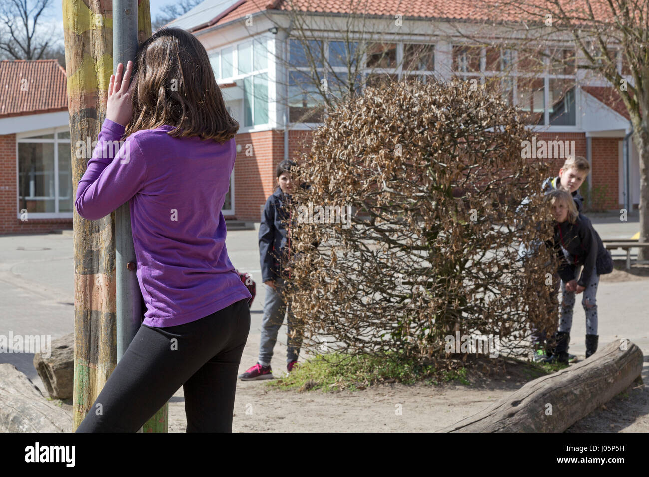 Schülerinnen und Schüler an der Grundschule spielen verstecken und suchen in Pause, Niedersachsen, Deutschland Stockfoto