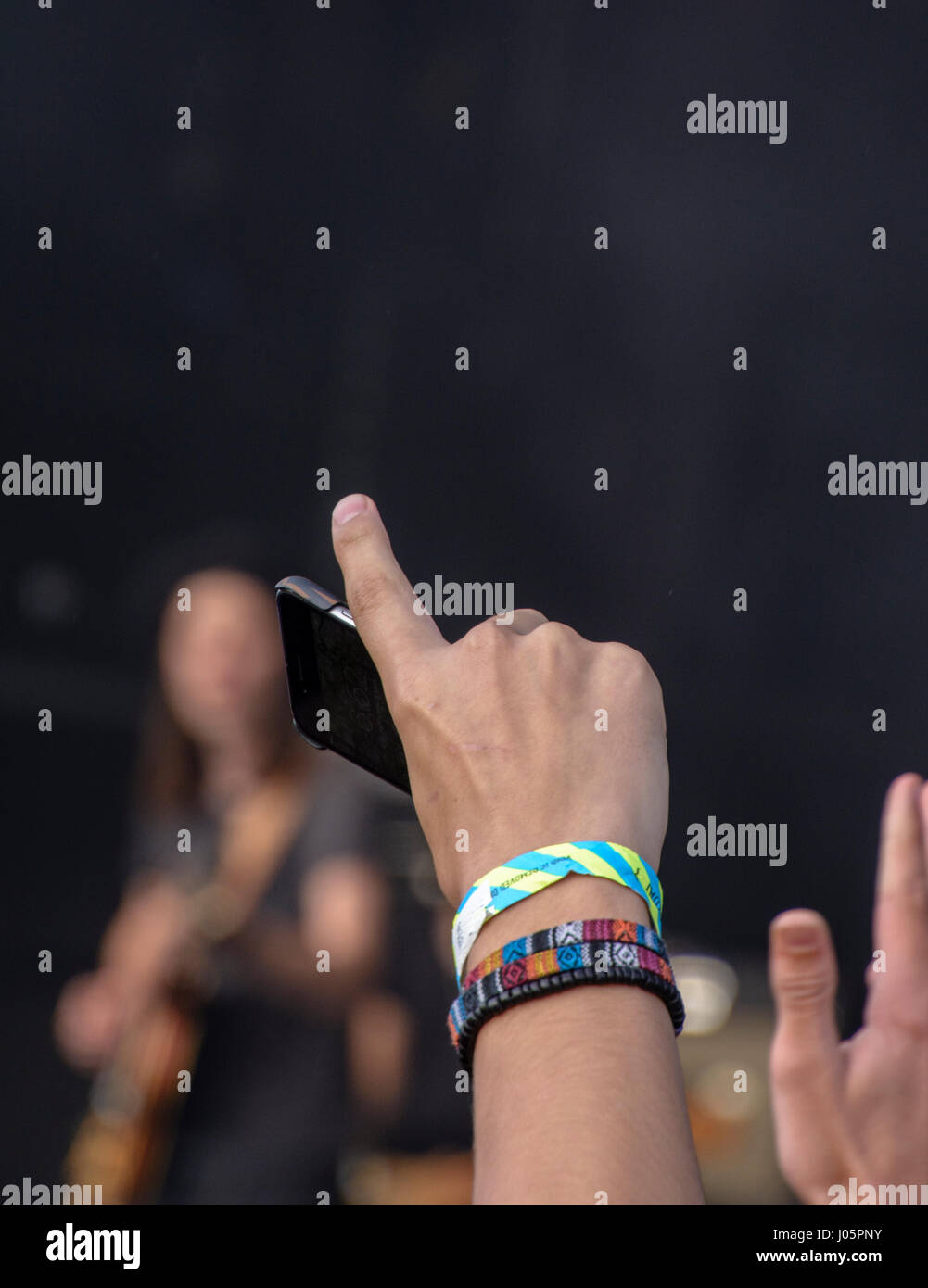 Treuen Fan mit einem Handy in der hand winkt ein Musiker auf der Bühne beim Festival Nr. 6 in Wales Stockfoto