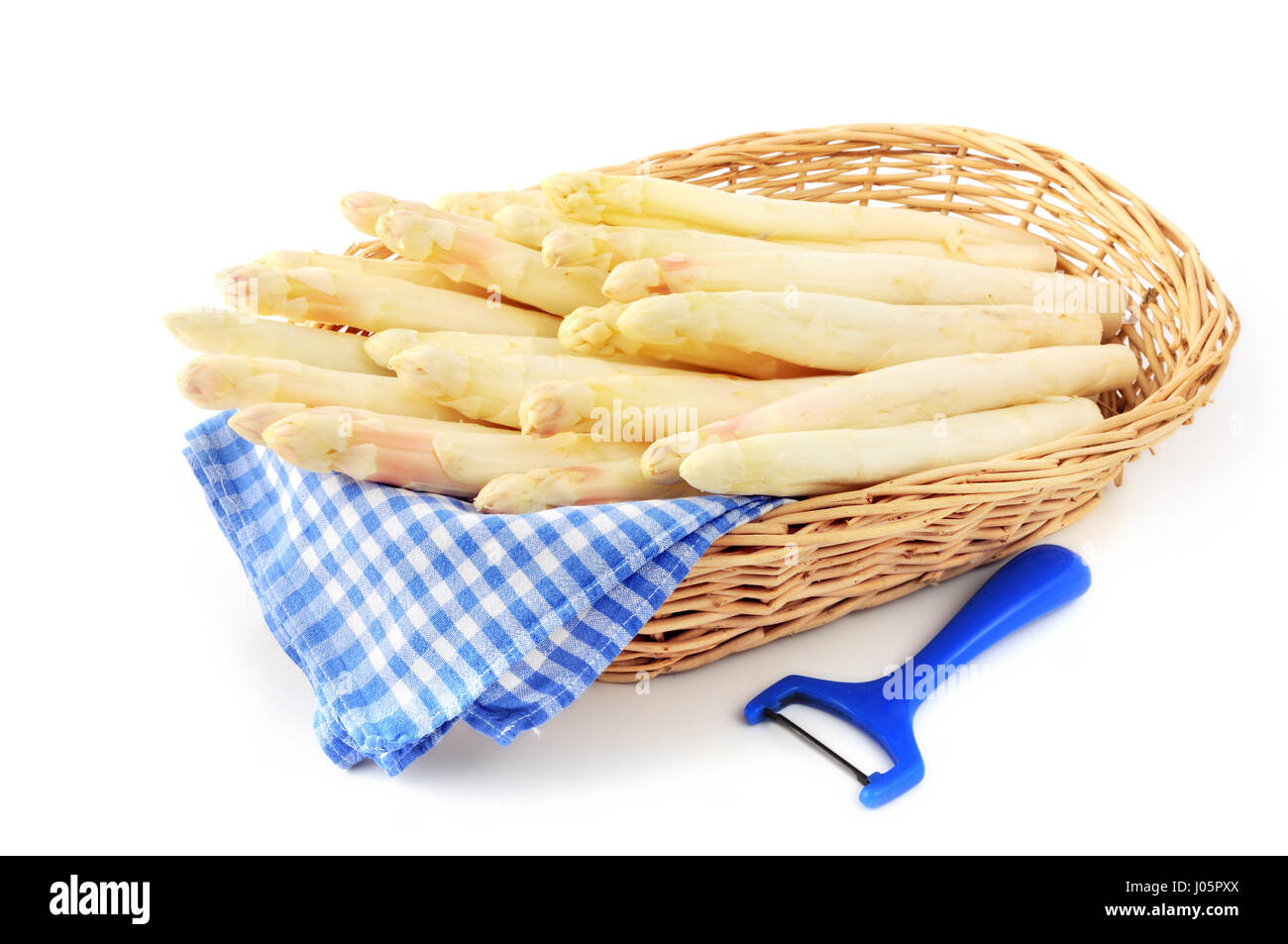 Korb mit weißem Spargel und Gemüseschäler. blau weiß karierten Stoff. Stockfoto