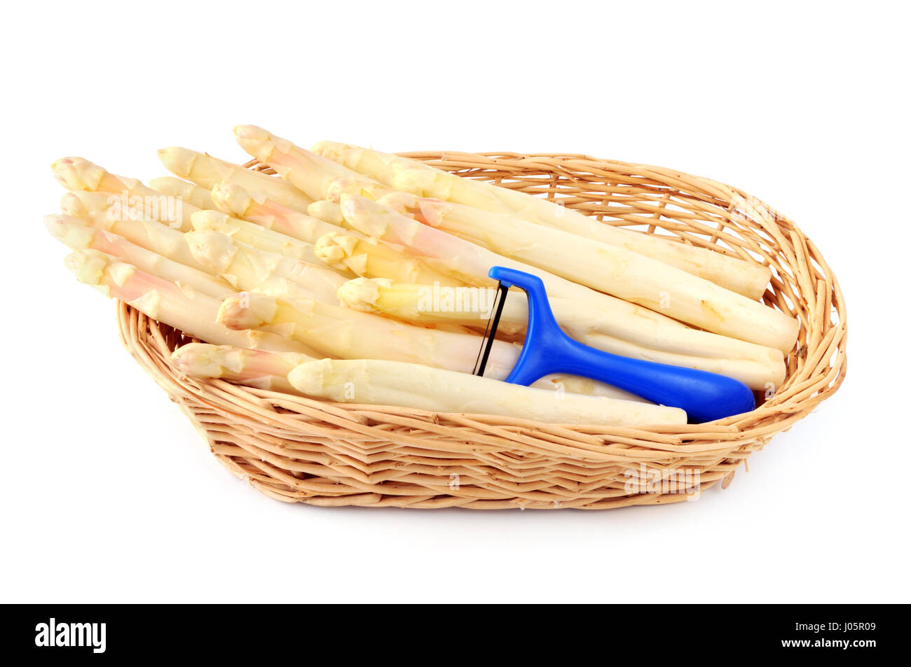 Spargel in einem Korb mit Gemüseschäler. weißen Hintergrund isoliert. Stockfoto
