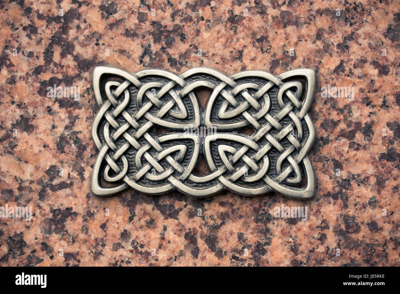 Gusseisen keltischen Knoten auf einer Steinoberfläche. Stockfoto