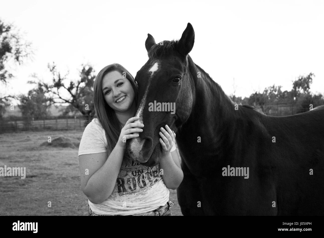 schwarze und weiße Mädchen kuscheln Pferd Stockfoto