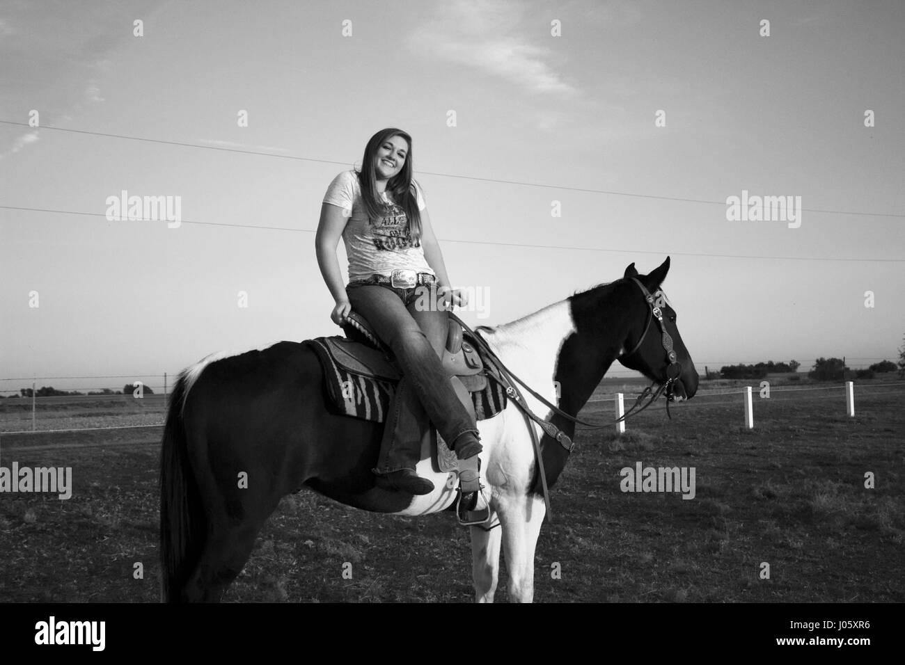 schwarze und weiße Mädchen auf Pferd Stockfoto