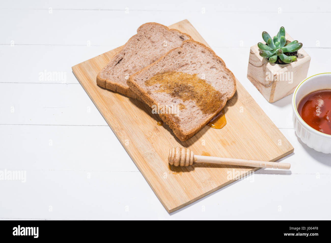 Nahaufnahme der Scheibe Toastbrot mit Honig auf Holztisch Stockfoto