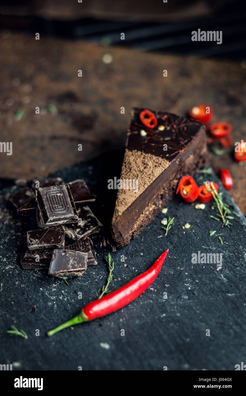 Stück dunkler Schokoladenkuchen mit roten Paprika. Das Restaurant oder Café-Atmosphäre. Retro. Jahrgang Stockfoto
