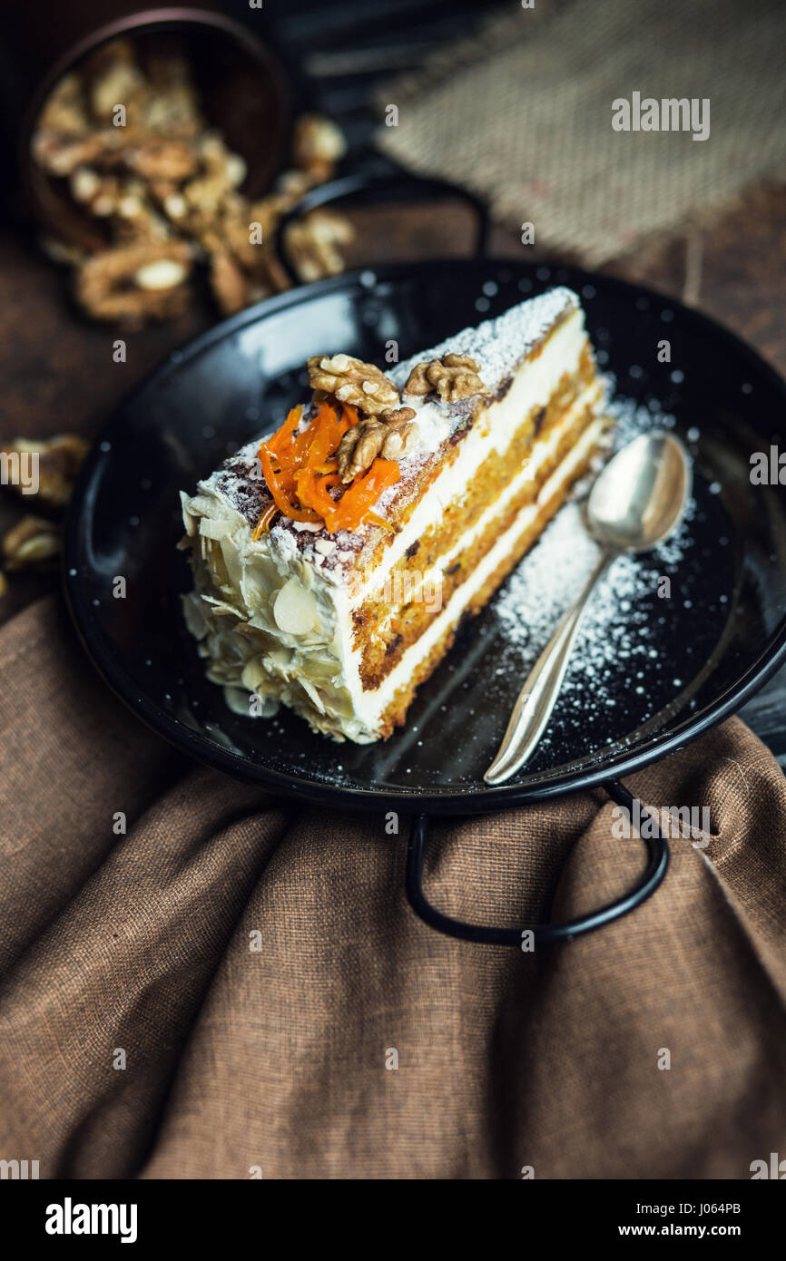 Stück Karottenkuchen mit Frischkäse und Walnüssen. Das Restaurant oder Café-Atmosphäre. Jahrgang Stockfoto