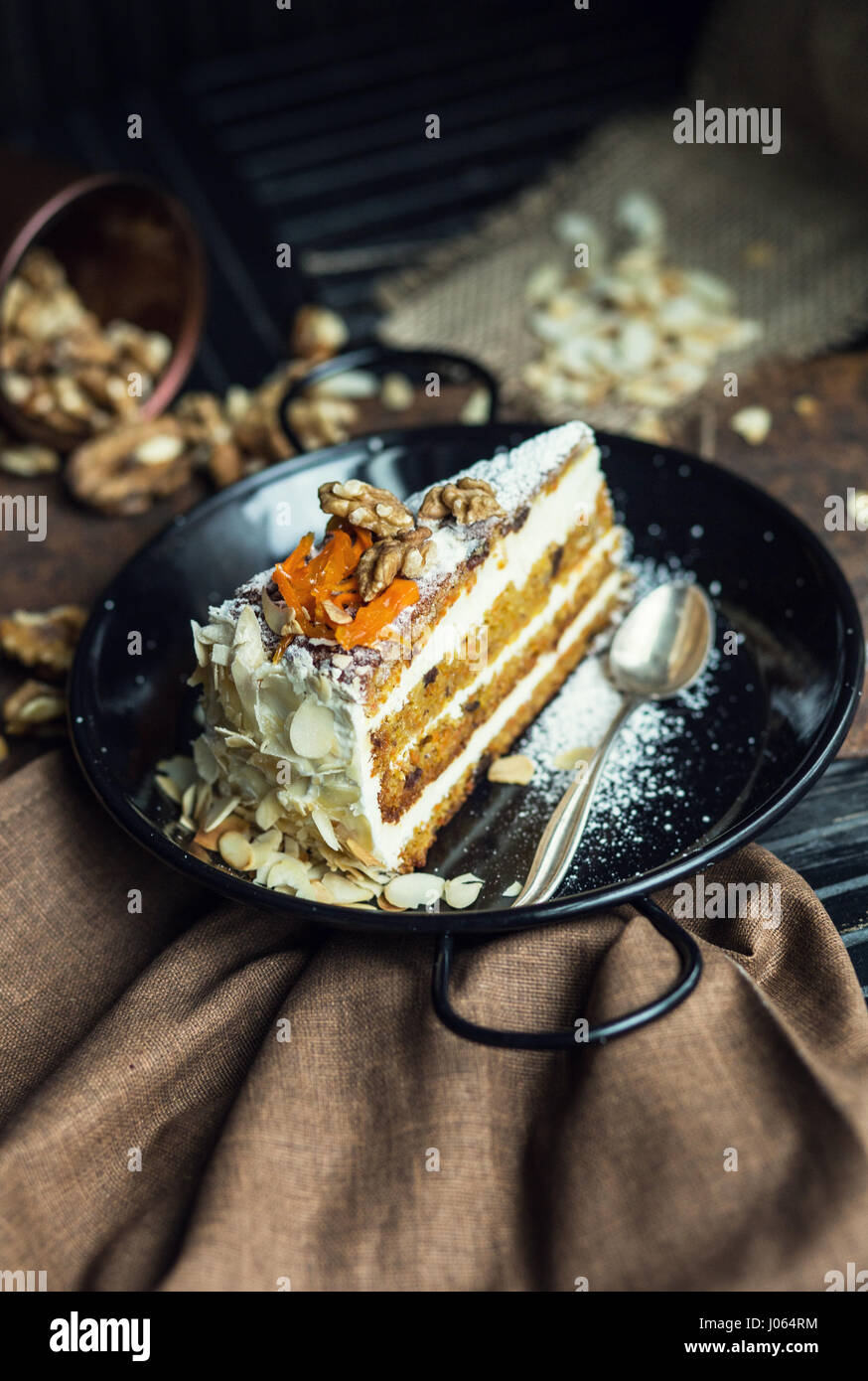 Stück Karottenkuchen mit Frischkäse und Walnüssen. Das Restaurant oder Café-Atmosphäre. Jahrgang Stockfoto