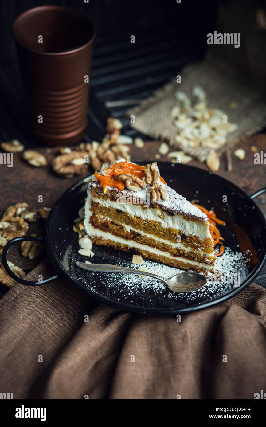 Stück Karottenkuchen mit Frischkäse und Walnüssen. Das Restaurant oder Café-Atmosphäre. Jahrgang Stockfoto