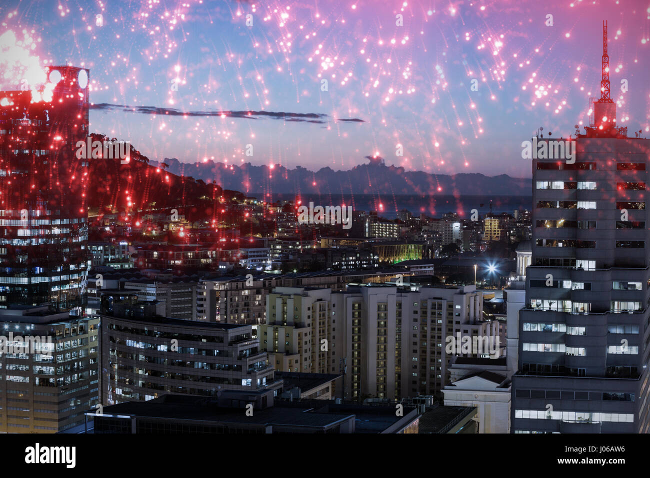 Weiße Feuerwerk explodierte beim schwarzen Hintergrund beleuchtete Gebäude in der Stadt gegen Himmel Stockfoto