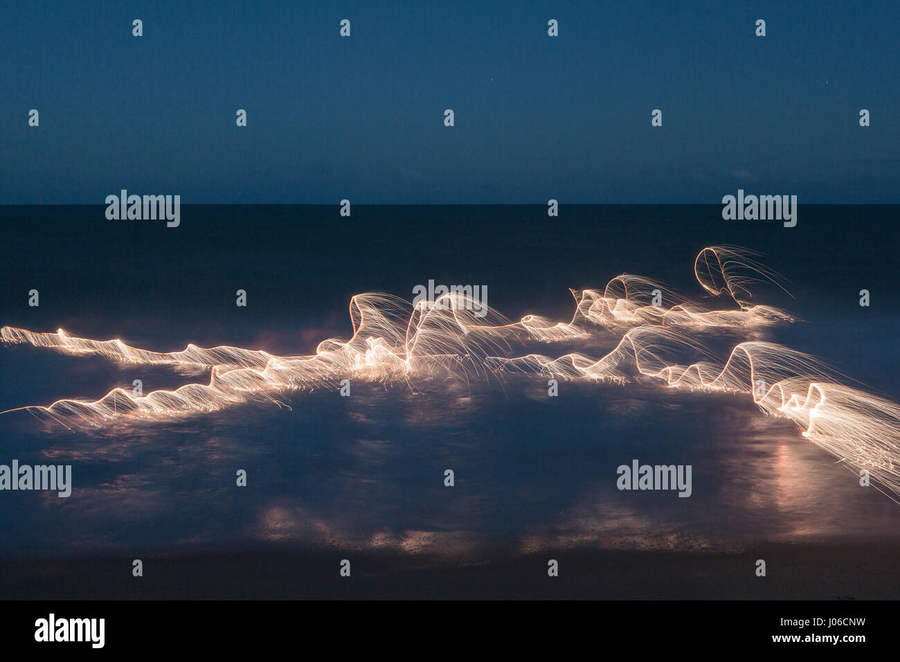 BRASILIANISCHE MITTELLAND, Brasilien: Feuerwerk haben verwendet, um einzigartige Kunstwerke schaffen, die Vergänglichkeit des Lebens darstellt. Die Serie namens "Einheiten" zeigt feurig orange wirbelt und Streifen gegen natürliche Einstellungen überlagert.  Lichtmuster lässt sich über dem Wasser tanzen, Felsen und sand sowie mächtigen alten Bäumen in ein spektakuläres Feuerwerk. Brasilianische Fotograf Vitor Schietti (30) schuf dieses leuchtende Kunstwerk in seinem Heimatland mit der brasilianischen Mittelland als seinen Hintergrund. Stockfoto