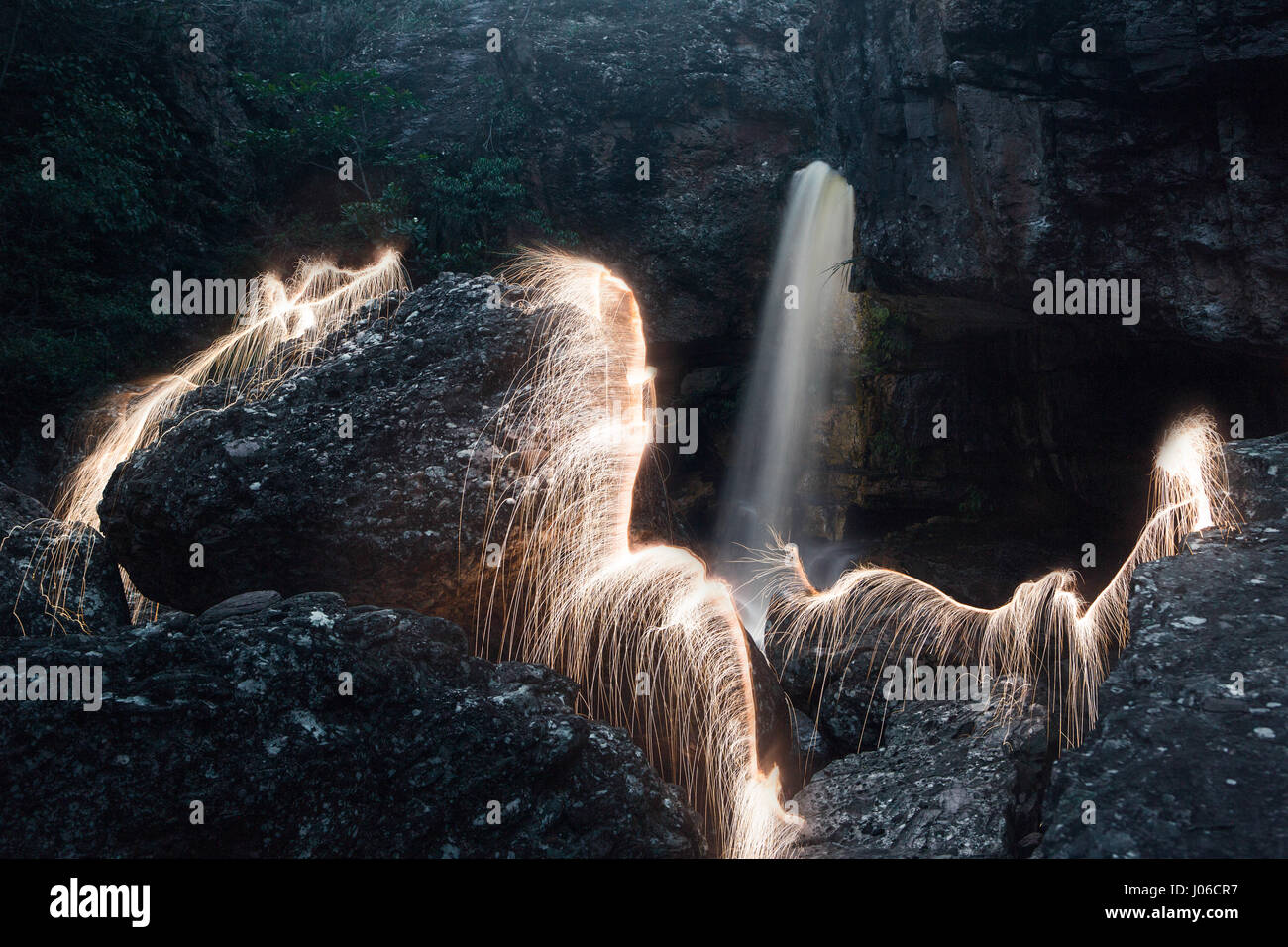 BRASILIANISCHE MITTELLAND, Brasilien: Feuerwerk haben verwendet, um einzigartige Kunstwerke schaffen, die Vergänglichkeit des Lebens darstellt. Die Serie namens "Einheiten" zeigt feurig orange wirbelt und Streifen gegen natürliche Einstellungen überlagert.  Lichtmuster lässt sich über dem Wasser tanzen, Felsen und sand sowie mächtigen alten Bäumen in ein spektakuläres Feuerwerk. Brasilianische Fotograf Vitor Schietti (30) schuf dieses leuchtende Kunstwerk in seinem Heimatland mit der brasilianischen Mittelland als seinen Hintergrund. Stockfoto