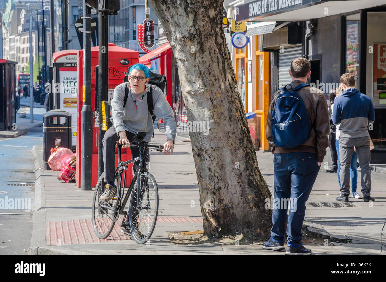 Ein Radfahrer mit blauen Haaren auf Whitechapel High Street in London. Stockfoto