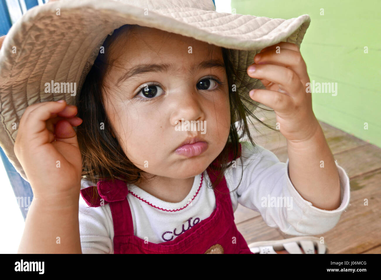 21 Monate Baby Mädchen spielen mit einem riesigen Hut Stockfoto