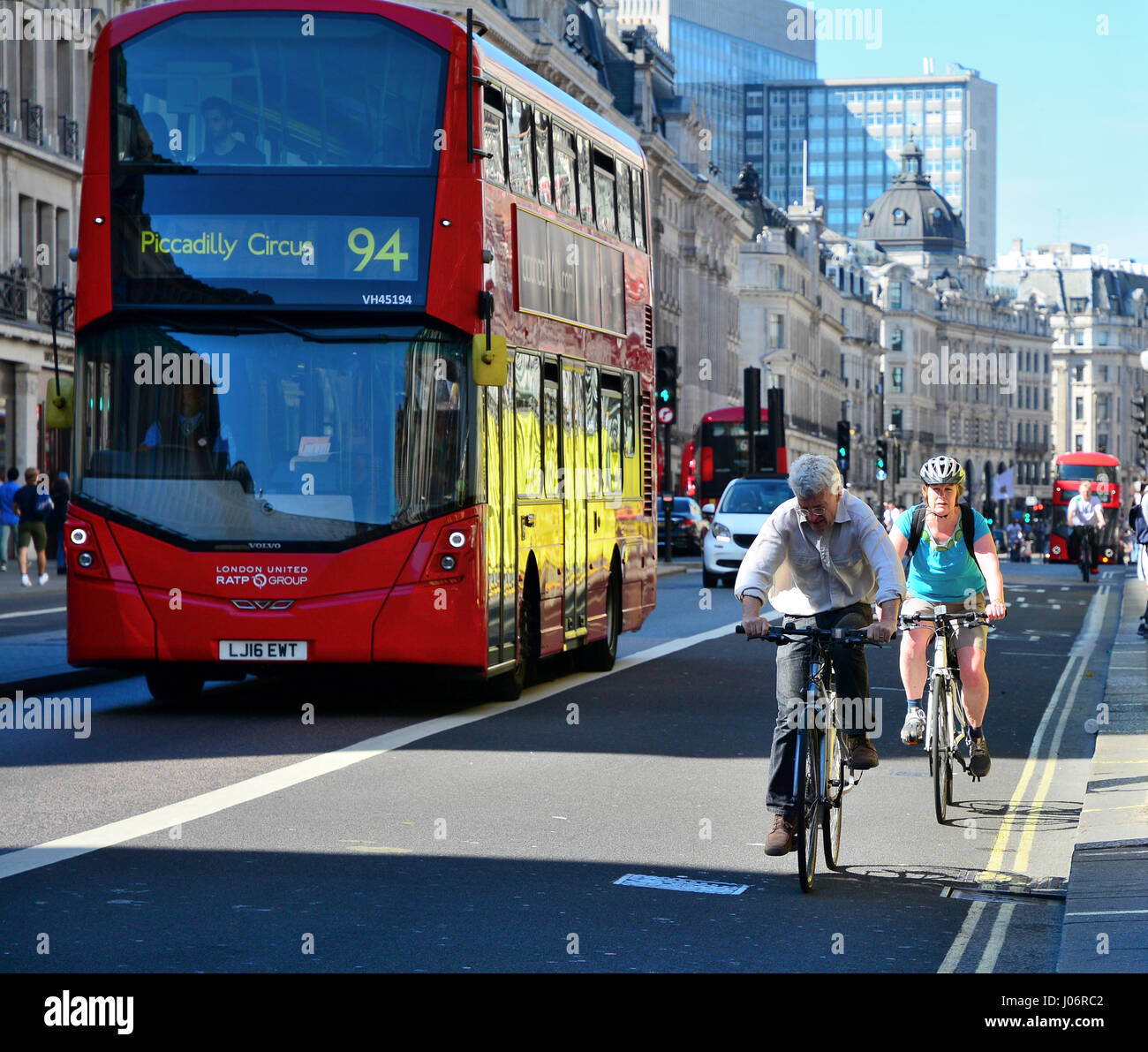 Radfahrer auf Busspur durch roten Doppeldecker-Bus in London Stockfoto