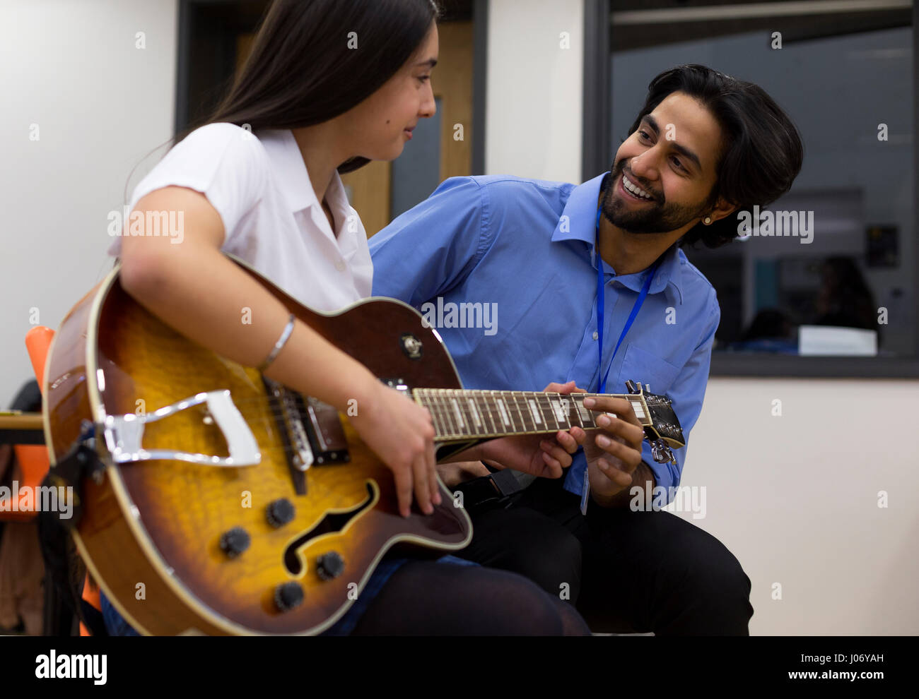 Musiklehrer, hilft ein Schüler lernen, Gitarre zu spielen. Stockfoto
