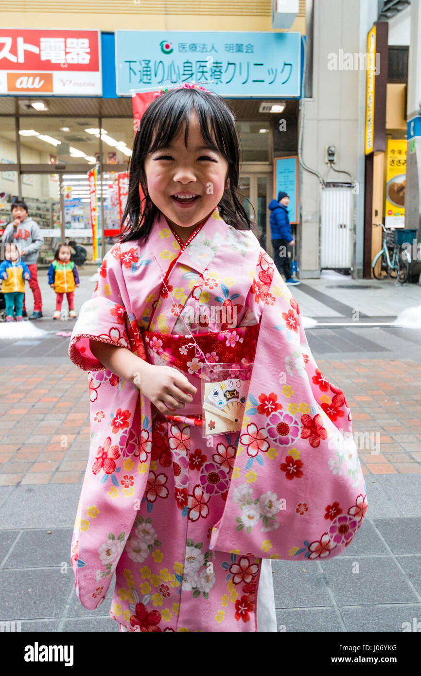 Japan, Kumamoto, Yosakoi Dance Festival. Close-up. Wenig lächelnde Mädchen  in rosa kimono Tanz in der Shopping Mall mit Dance Team hinter ihr. Auge -  Kontakt Stockfotografie - Alamy