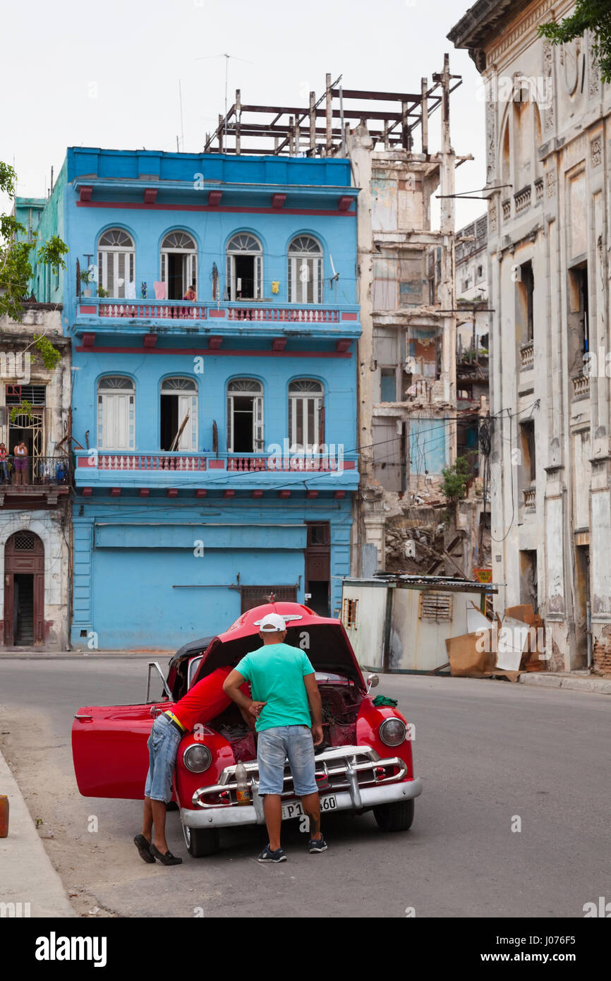 Zwei kubanische Männer reparieren ihr Auto mitten auf der Straße in Alt-Havanna, Kuba. Stockfoto