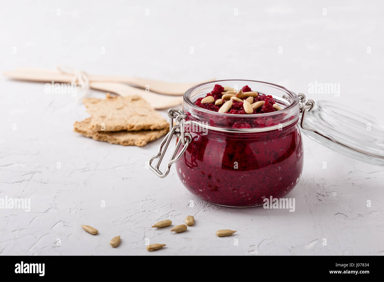 Hausgemachte rote Bete und Sonnenblumenkerne-dip im Glas serviert mit Cracker Stockfoto