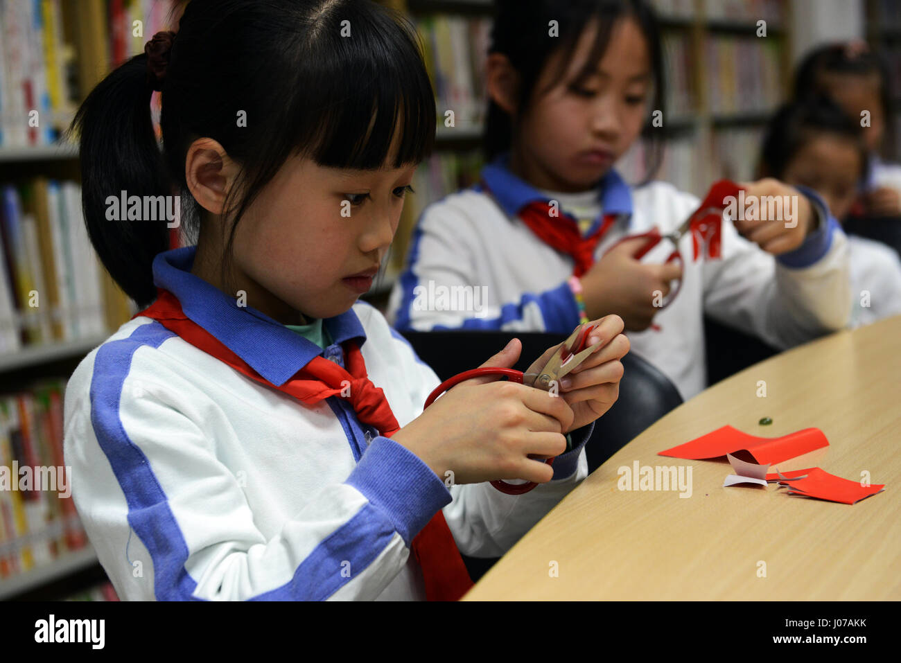 Kleine Kinder lernen die Kunst des Jianzhi - traditionelles Chinesisch Papier schneiden. Stockfoto