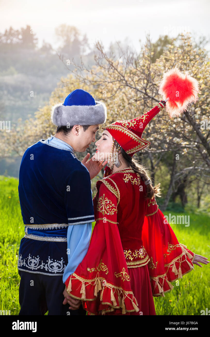 Paar im kasachischen ethnische Kostüm küssen im Frühjahr blühen Apfel  Garten Almaty am wunderschönen Sonnenuntergang, Kasachstan Stockfotografie  - Alamy