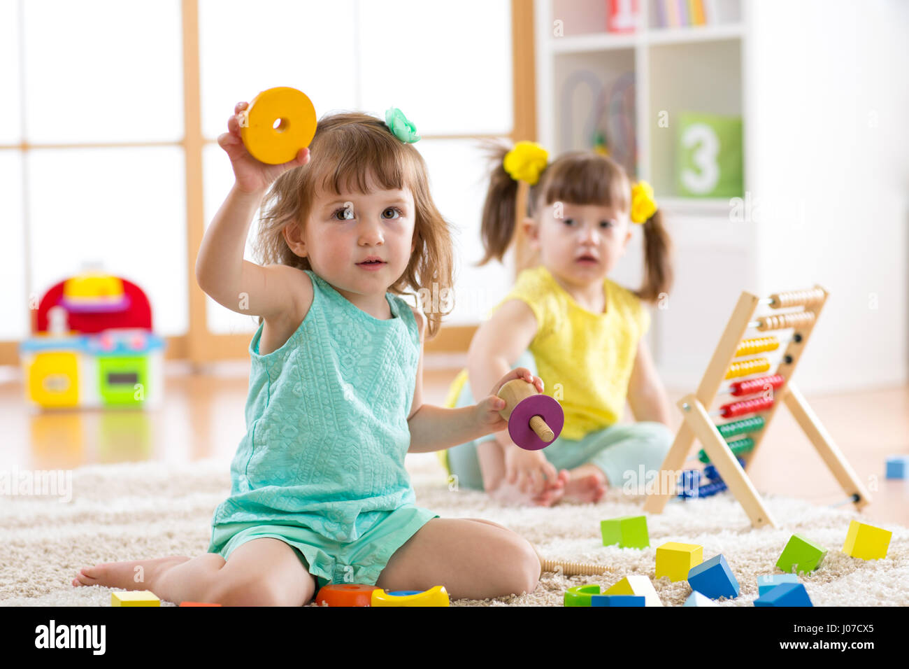 Kinder Kleinkinder und Vorschüler Mädchen spielen logische Spielzeug lernen Formen, arithmetische und Farben zu Hause oder im kindergarten Stockfoto