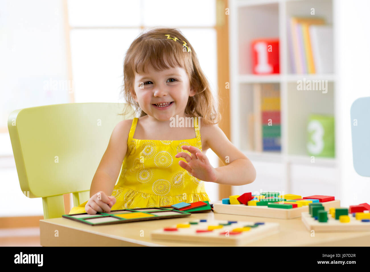 Kind Mädchen spielen und lernen, Farben, Formen und Größen an Tisch zu Hause Stockfoto
