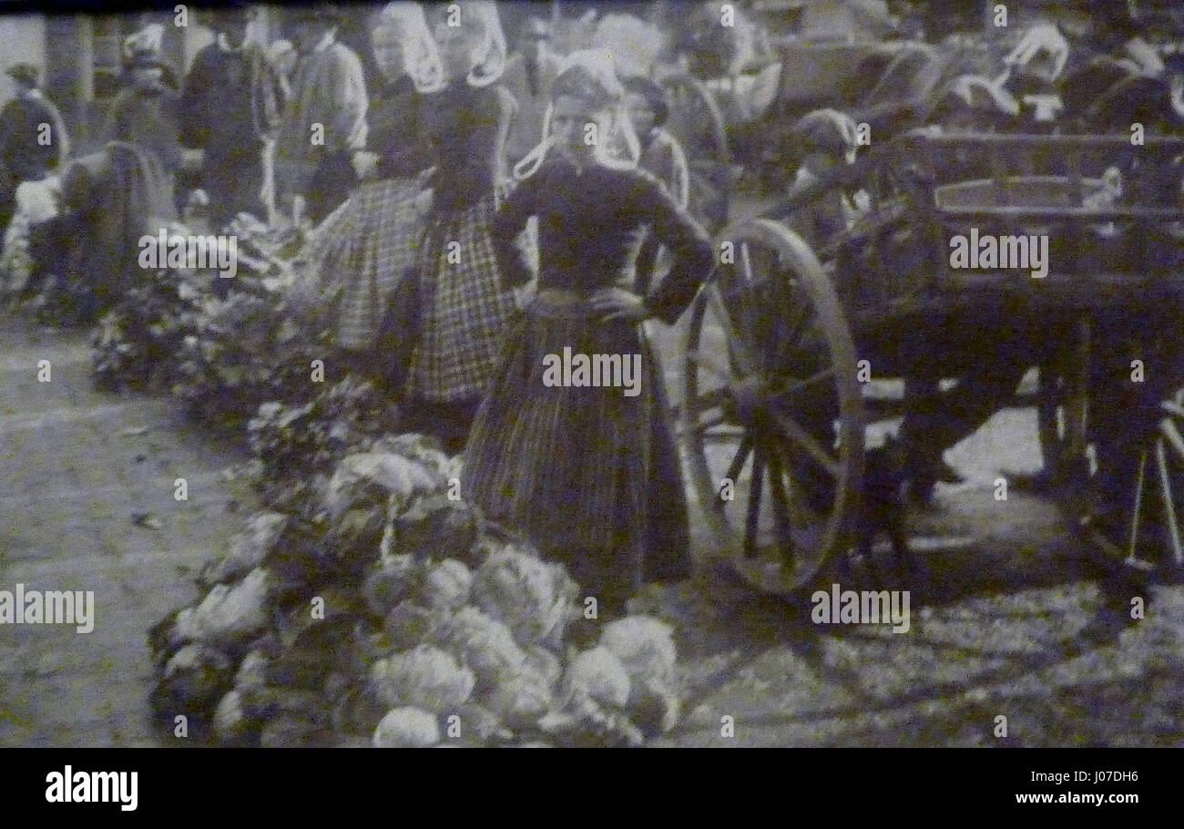 „Scène de marché“ von Gaston Maury, gemalt 1907, fängt eine lebhafte Marktszene in Quimper, Frankreich, ein. Die detaillierten Pinselarbeiten und die Verwendung von Licht spiegeln die lebhafte Atmosphäre des Marktplatzes wider, einer der wichtigsten sozialen Zentren im ländlichen Frankreich des frühen 20. Jahrhunderts. Stockfoto