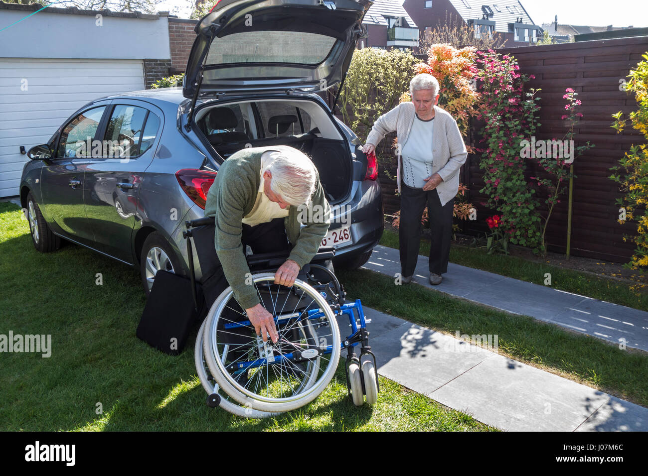 Ältere Mann Montage Rollstuhl von körperlich behinderten älteren Frau vor Auto nach der Rückkehr zu Hause Stockfoto